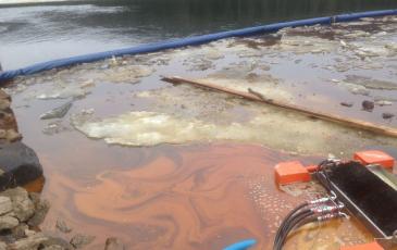 Удержание боновыми заграждениями загрязненного льда и нефтесодержащей эмульсии на водной поверхности