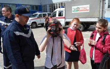 Заместитель начальника ПАСФ Самарского центра «ЭКОСПАС» Журавчак И.Н. помогает детям примерить дыхательный аппарат